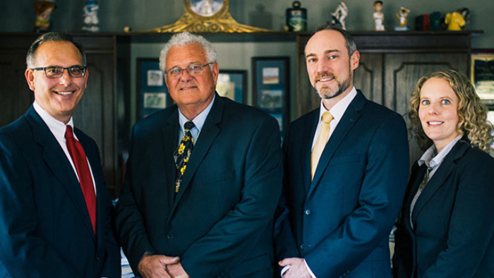 all attorneys Four workers' compensation attorneys pose for a photo.