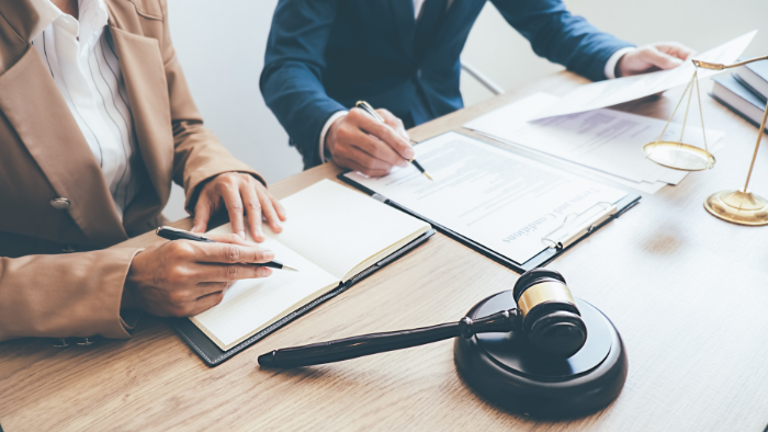 lawyers-sit-at-a-table-with-a-gavel Lawyers sit at a table with a gavel to review a case