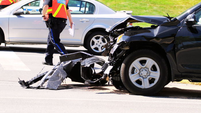 Car accident scene A car is seen after a car accident with a policeman walking away